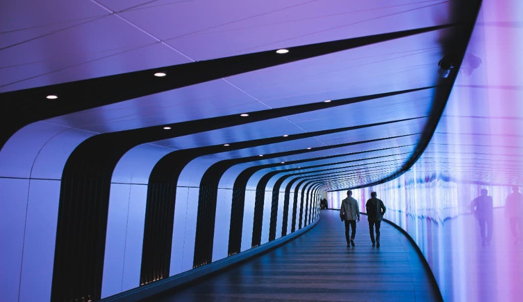 A luminous pedestrian tunnel in blue and purple light